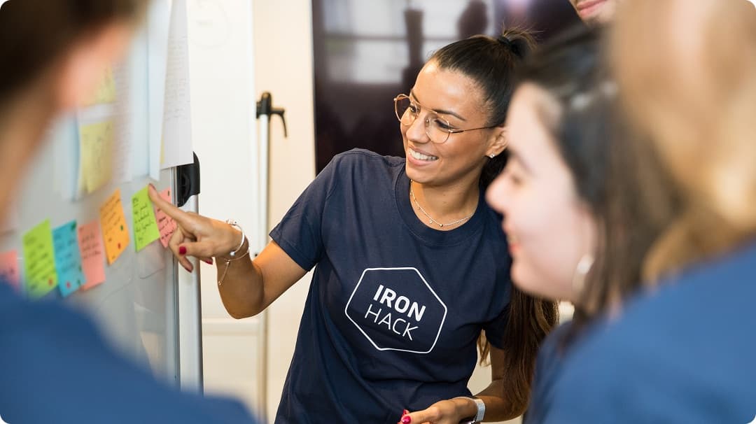 An Ironhack facilitator mapping a team's workflow on a sticky-note board
