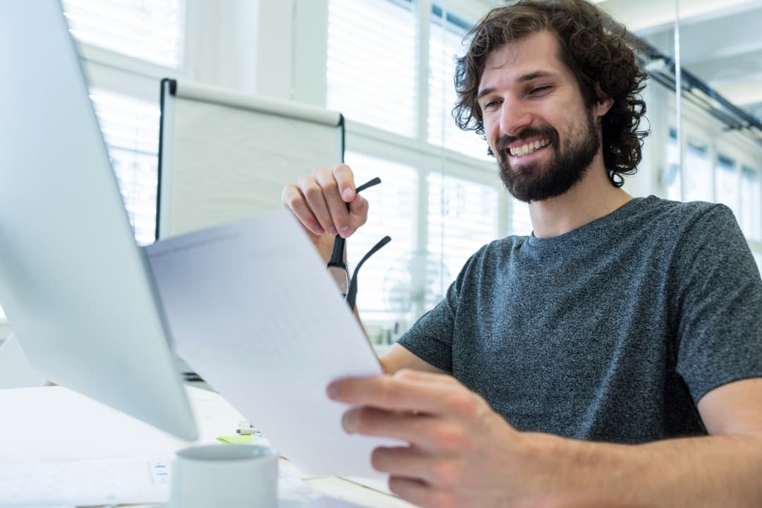 Una persona revisando un informe impreso en su mesa de trabajo